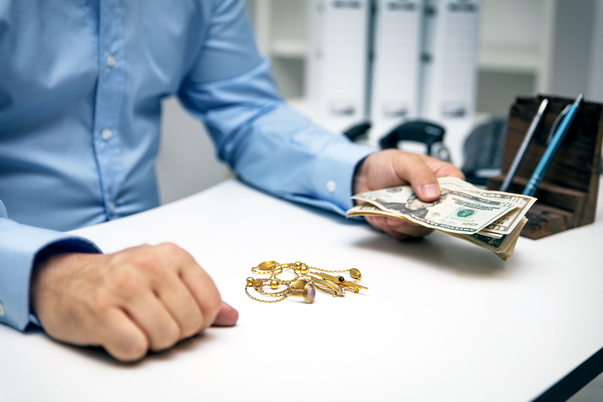 Pawnbroker paying cash for gold jewelry